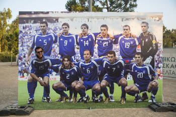 A football team stands hugging and posing for a commemorative photo